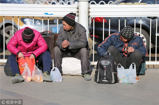 2018年2月6日,农民工在青岛火车站赶火车.