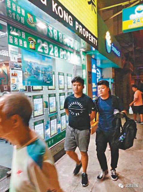 手机炸弹:狂徒用手机遥控炸弹袭港警 2人落网照片曝光(图) 其中一名涉嫌旺角引爆遥控炸弹案的疑犯(左二)由探员押返警署扣查。来源:香港《文汇报》