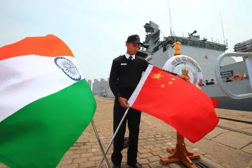 ▲2014年4月20日，在中国青岛，参加“海上合作—2014”演习的印度海军“什瓦利克”号护卫舰的水兵在码头舷梯口摆放中印两国国旗。（新华社）