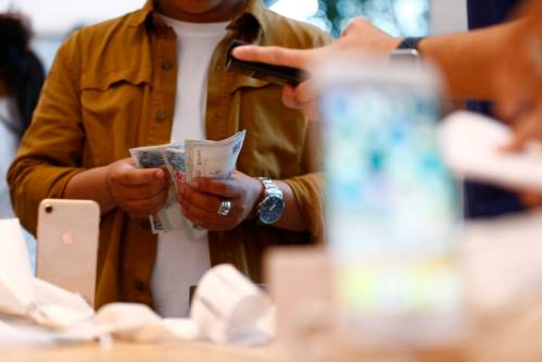 一名消费者在一家苹果专卖店购买手机。 新华社/路透