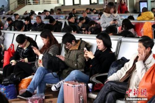  资料图：移动互联网时代，旅客都拿着手机打发时间。中新社记者 王中举 摄