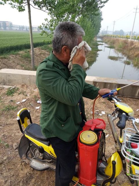 图片上这位大叔是鲁西南的农民,他正往药筒里倒水.