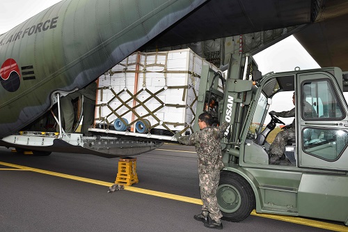  11日，在济州国际机场，工作人员正将济州产柑橘装到韩国空军的运输机上。（韩联社）