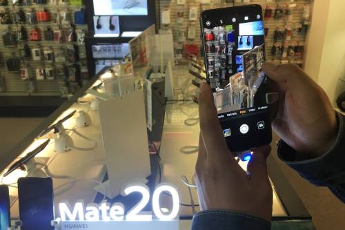 图为顾客在一家电子用品商场体验华为手机拍照功能。新华社