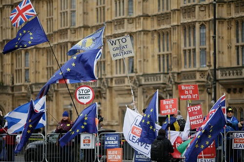 2019年1月14日，在英国伦敦，支持脱欧和反对脱欧的示威者在议会大厦外手举旗帜和标语牌。 新华社发