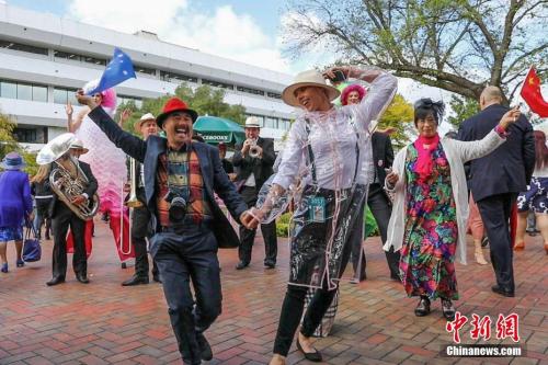 资料图片：中国游客参加“墨尔本赛马节”。图为一对来自中国的夫妇伴着乐队的音乐和歌声，与一位澳大利亚工作人员共舞。中新社记者 陶社兰 摄