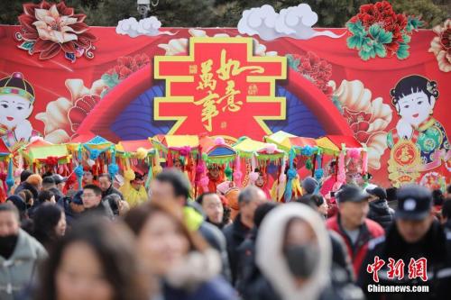 2月9日，游客在北京八大处公园庙会上游玩，观看传统民间花会表演。 盛佳鹏 摄