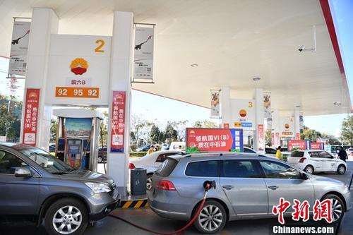 资料图：汽车在油站加油。中新社记者 刘冉阳 摄