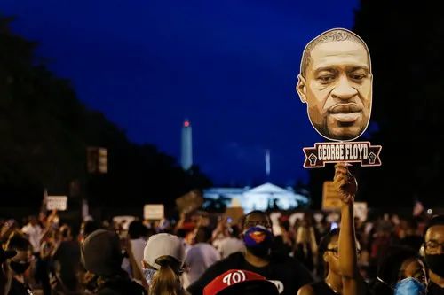 6月6日，在美国华盛顿，示威者手举乔治·弗洛伊德的头像参加示威活动。新华社/美联