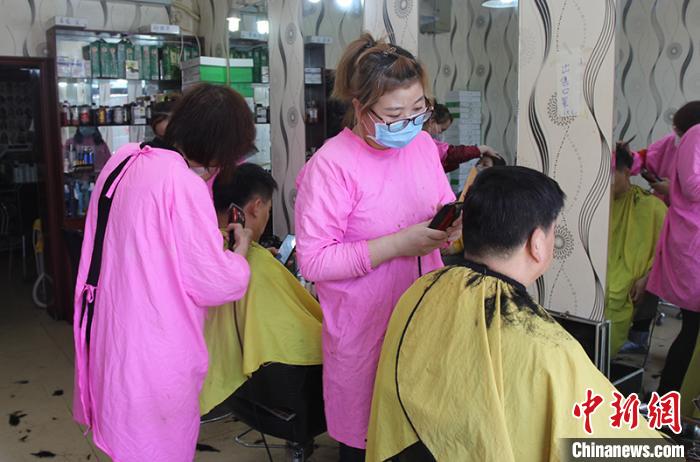 理发师戴口罩为市民理发.