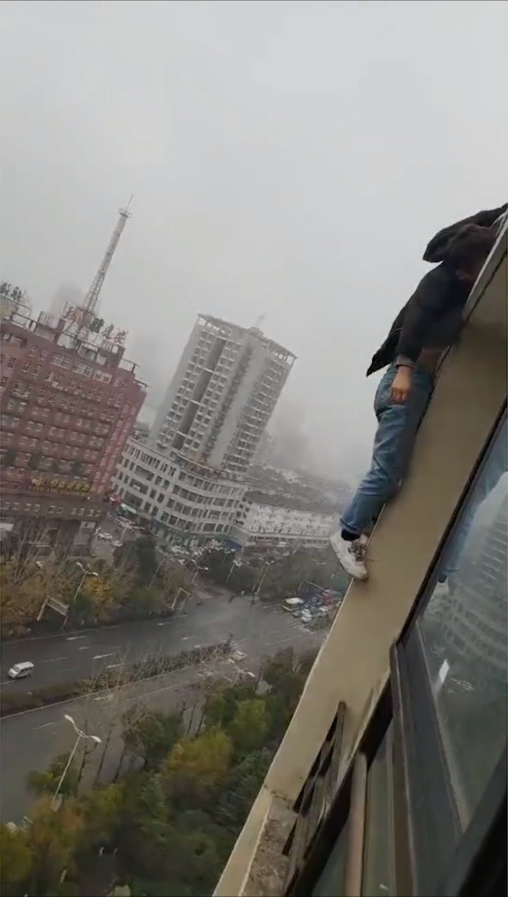 男子从楼上跳下瞬间被家人抓住胳膊