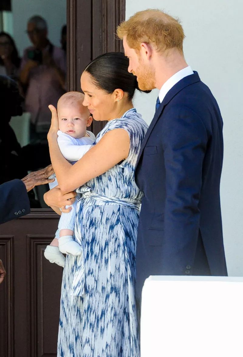 梅根出席活动,穿无袖连体裤暴露粗壮双臂,轻抚婴儿满眼都是母爱