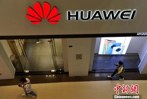 原料图:市民从华为产品专卖店旁通过。 中新社记者 张斌 摄