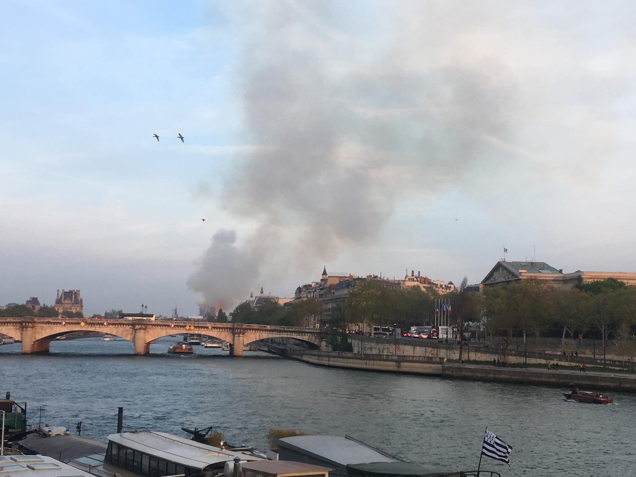 当地时间4月15日18时50分左右，巴黎圣母院有浓烟冒出，依稀能看见火光。受访者供图