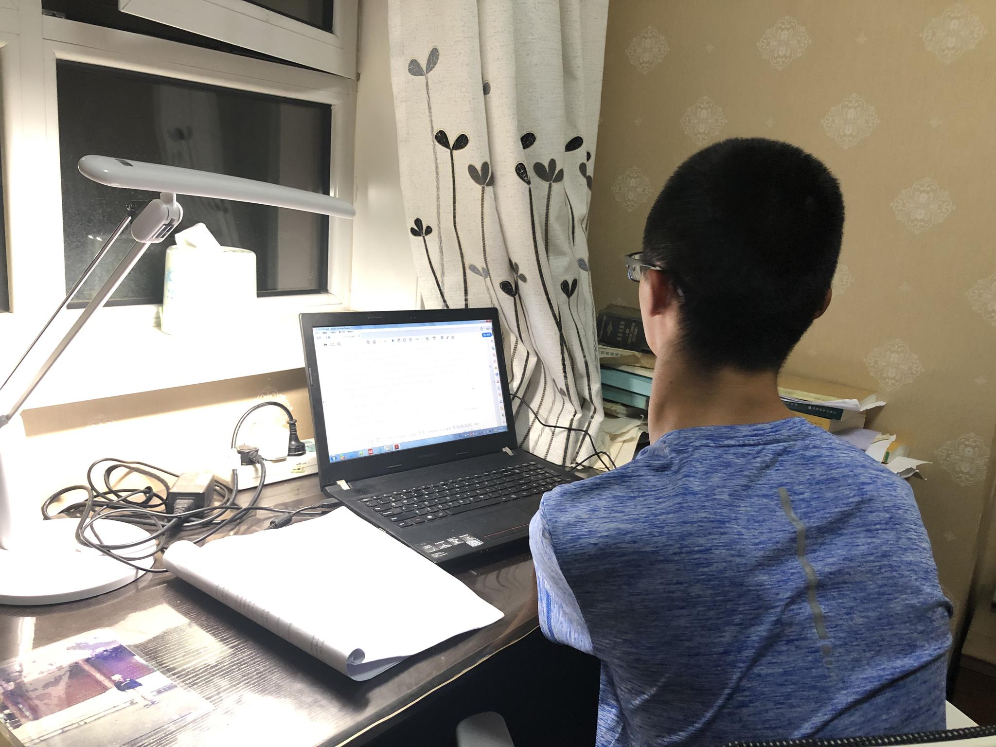 9月24日晚，谢炎廷在卧室里用电脑写论文。新京报记者王瑞锋 摄