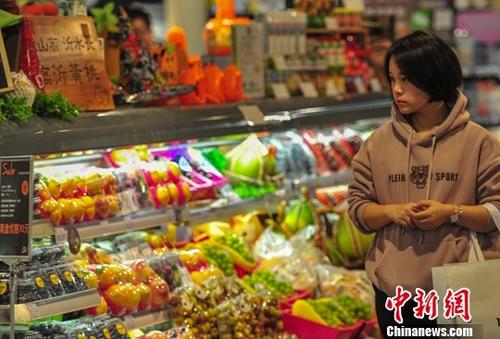 资料图：10月16日，一名消费者在超市选购商品。中新社记者 于海洋 摄