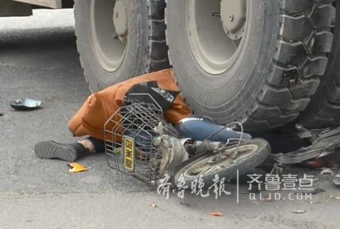 惨烈,电动车及车上的女子都被卷到大货车的左后轮下面,电动车被压扁