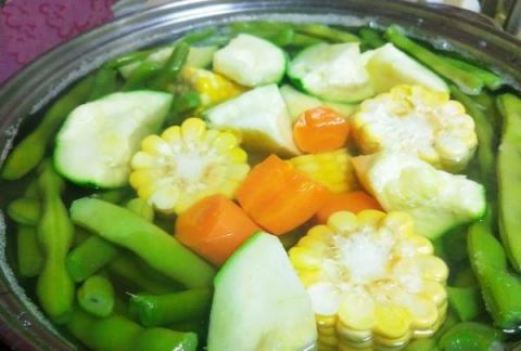 3 锅中放入足够清水,冷水下入四季豆,不加锅盖,敞开煮,大火烧开后转中