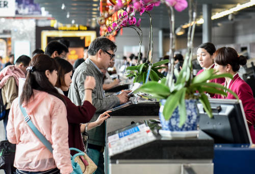 图为旅客在广州白云国际机场国际航班柜台办理值机。新华社