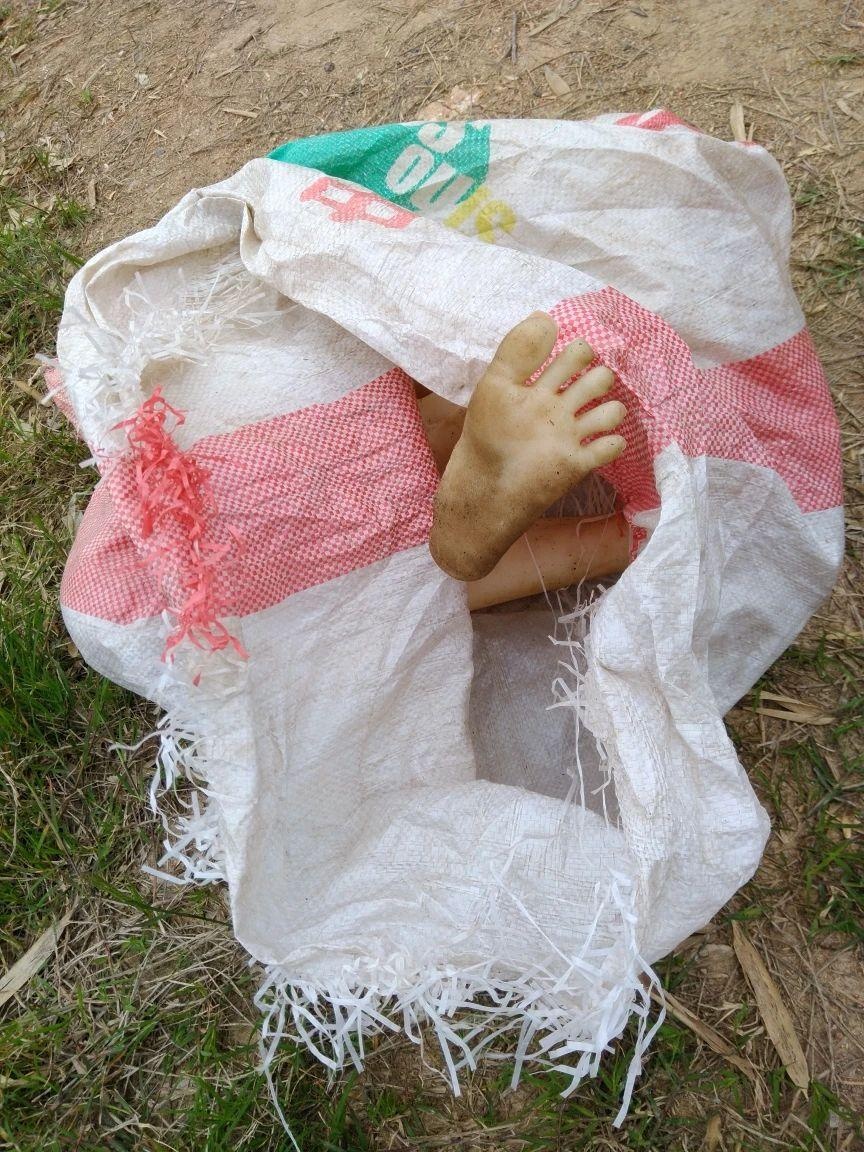 竹林里藏着的标志袋里露出一只"脚",好像还赤裸身体,民警一看原来是