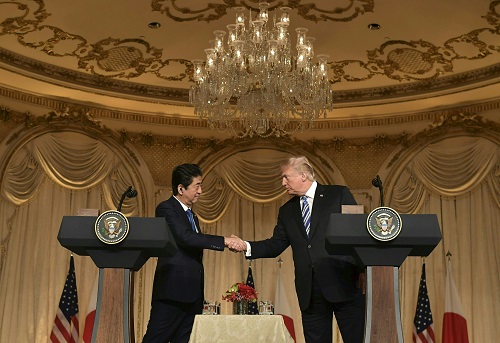 总统特朗普(右)和日本首相安倍晋三在于棕榈滩举行的联合记者会上握手