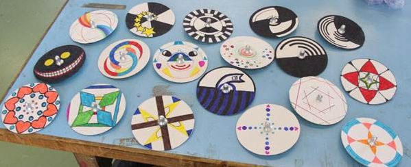 准备白纸板,剪刀,水彩笔,圆珠笔,出示事先准备好的陀螺让他转起来,七