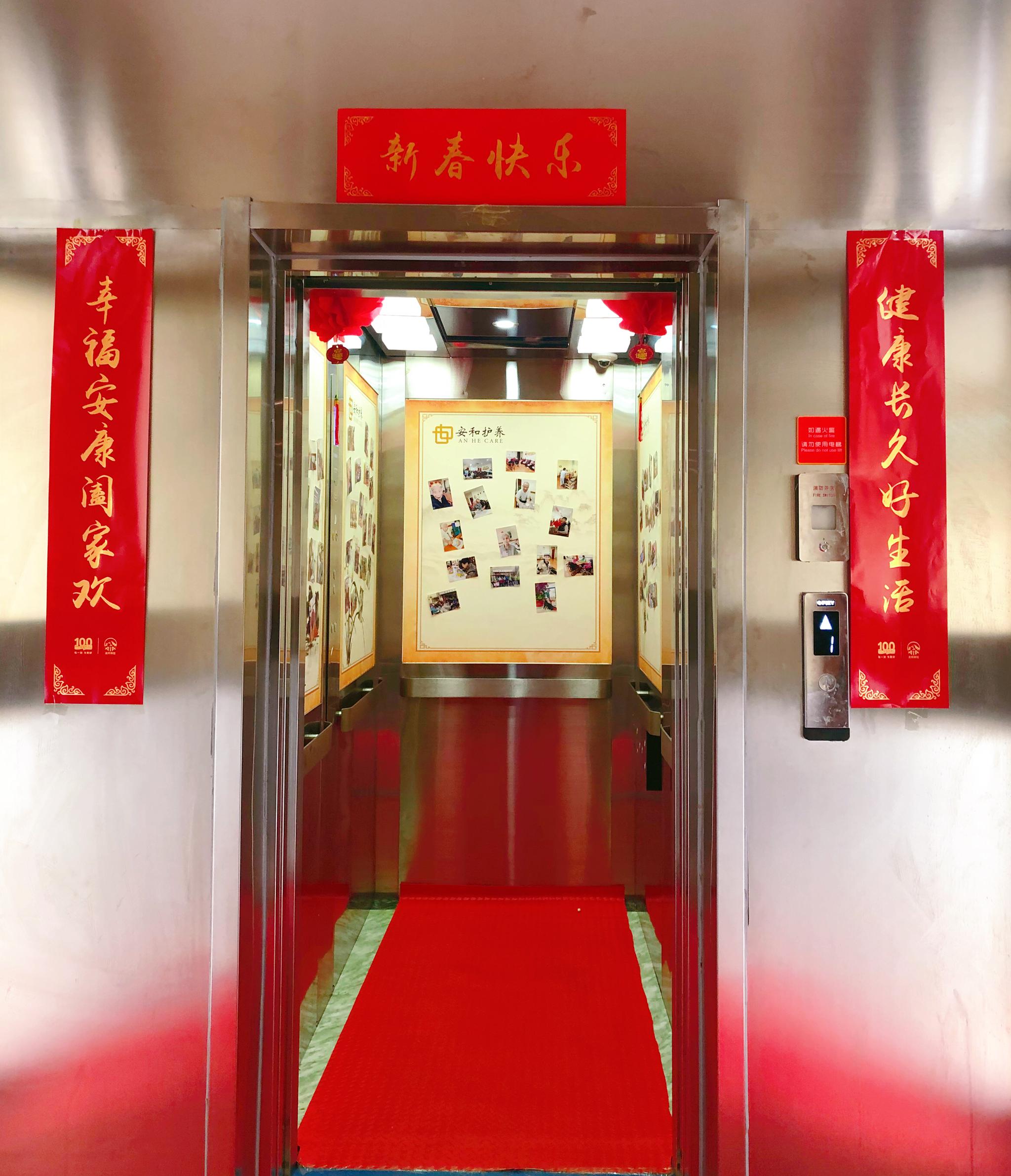 电梯里铺上了红地毯,门口还贴上大红对联,喜气洋洋