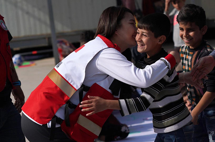 巴格达，中国红十字会工作人员与聚居区的孩子拥抱。