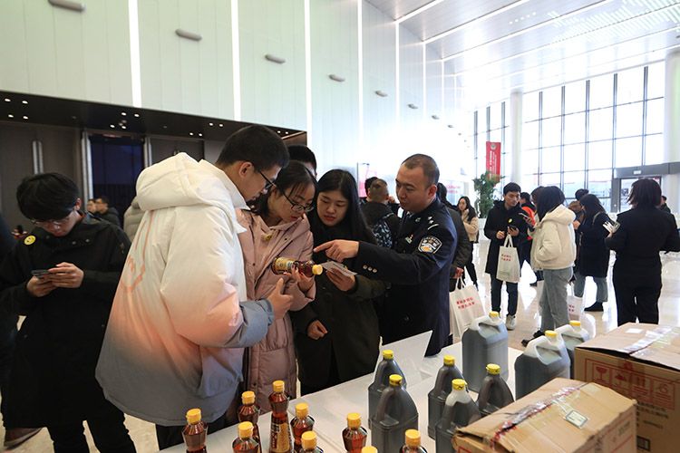 民警向市民介绍分辨假麻油的方法。