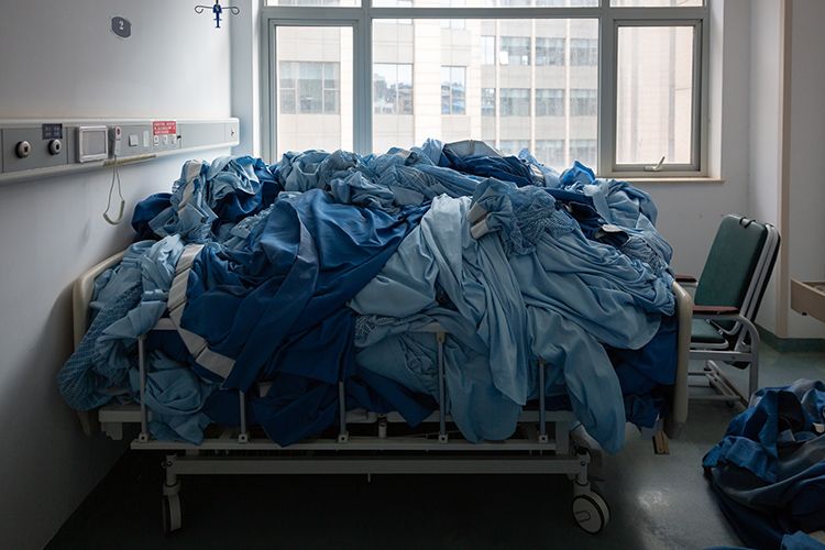  病区里床上用品和窗帘统一堆放，等待消杀人员清理。
