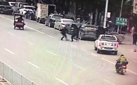  监控视频显示，行凶男子持刀伤人的地点，离执法车非常近。