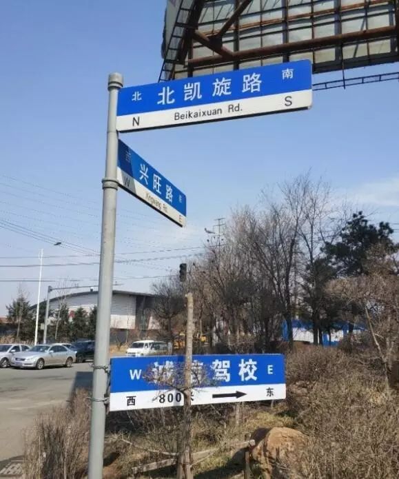 长春北凯旋路一驾校指示牌与路牌酷似,并挂在路牌杆上?