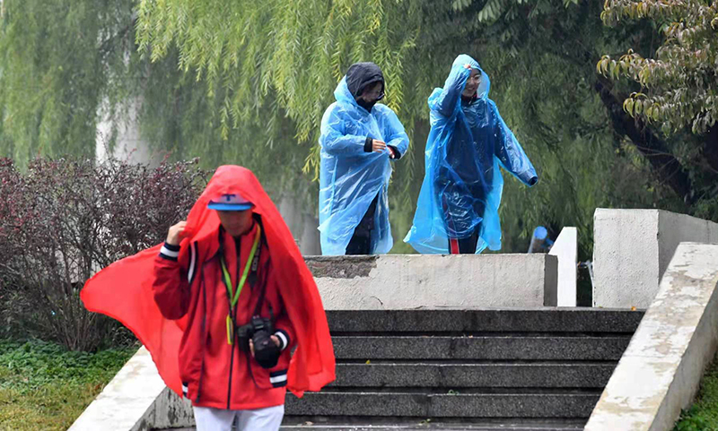 奥体中心,行人穿上了雨衣出行.