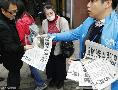 日本东京街头，民众关注明仁天皇退位时间确定的新闻报道。（图片来源：视觉中国）