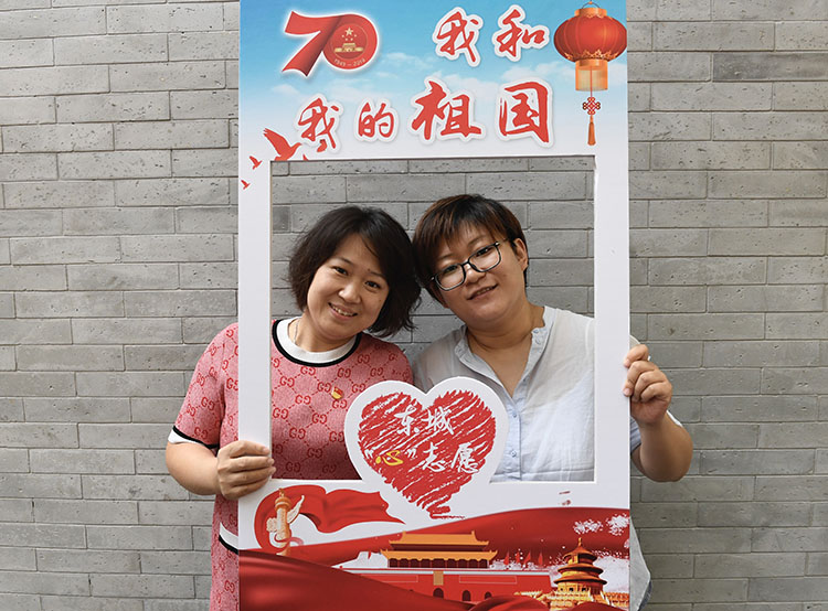 居民手持"我和我的祖国"画框合影.