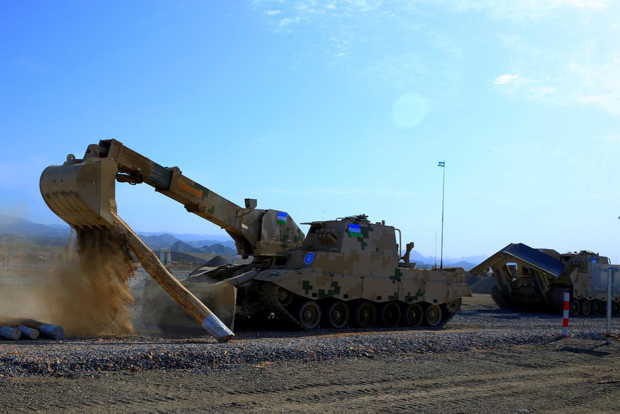 乌兹别克斯坦队履带式装甲多用工程车正在抓取圆木障碍 中国青年网 张