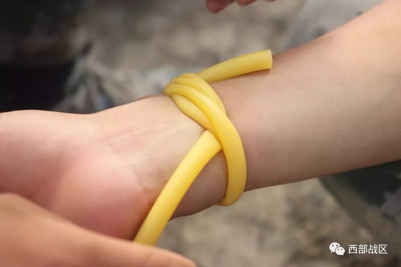 前头交左手,中食两指挟右手拉紧环体扎后头留5寸橡皮止血带的使用方法