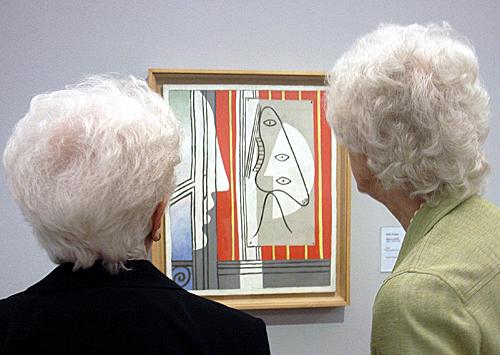 在西班牙首都马德里，两位老人在欣赏毕加索的画作。（新华社）