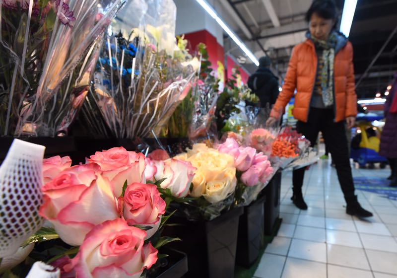 　　情人节前夕，消费者在超市内的鲜花摊位选购。新京报记者 吴宁 摄