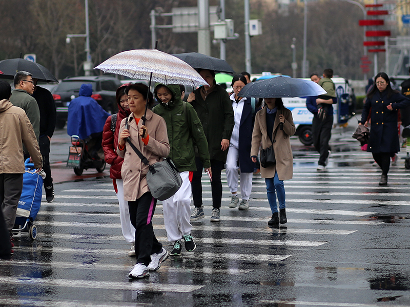 一场春雨降落京城.海淀黄庄,雨中赶路行人.海淀黄庄,市民雨中出行.