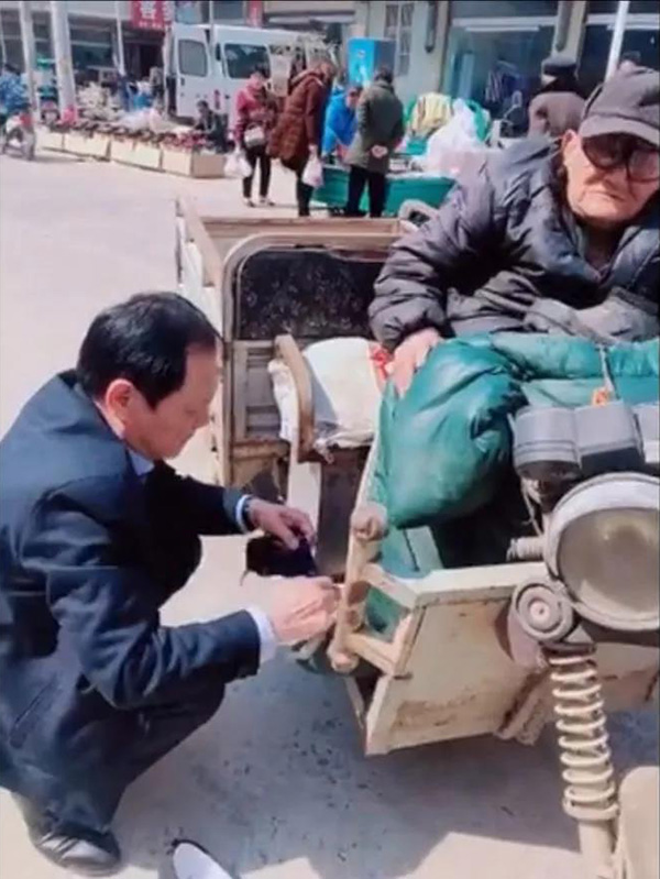 卢书林在给老人穿鞋袜。（视频截图）