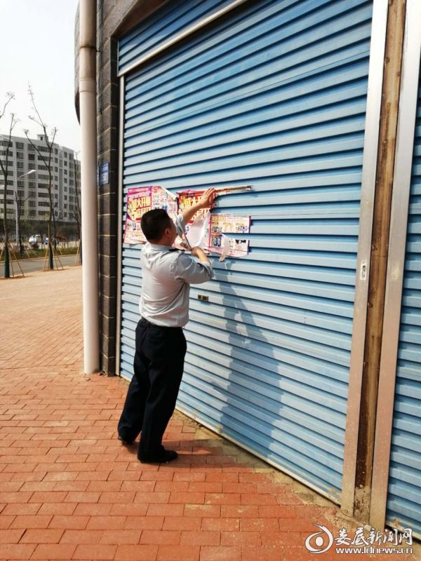 (周松青正在清理沿街粘贴的小广告)