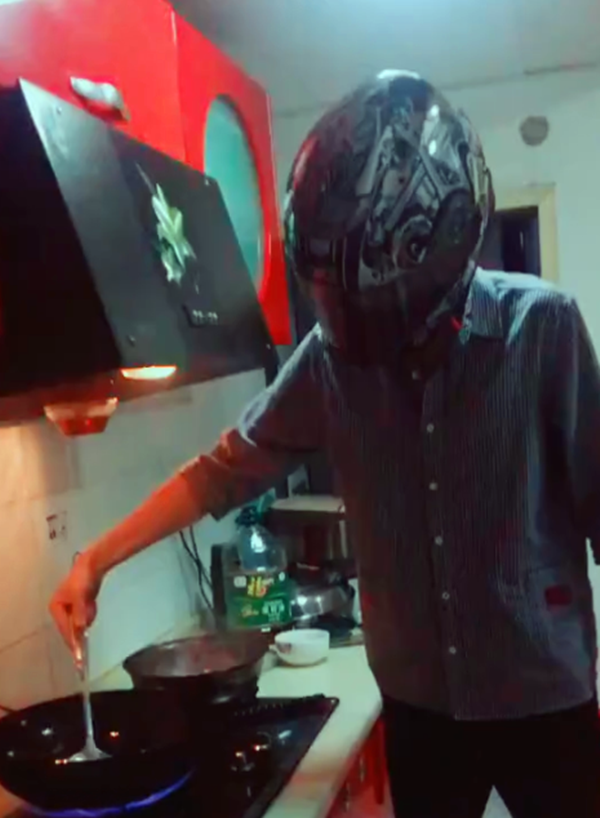不想油烫到脸小伙戴头盔炒菜做饭