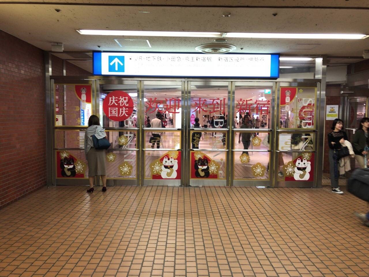 台风来临之际正值十一黄金周,日本新宿的地铁站出口打出了"庆祝国庆"