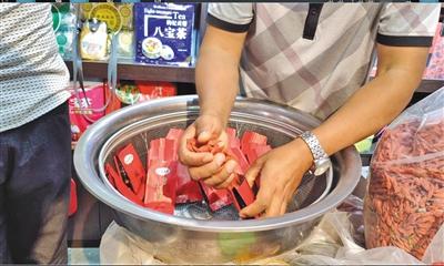 8月18日,宁夏中卫市鼓楼东街一枸杞专卖店,老板正在往有“中宁”字样的包装袋里装枸杞,但这些枸杞并不是产自中宁。