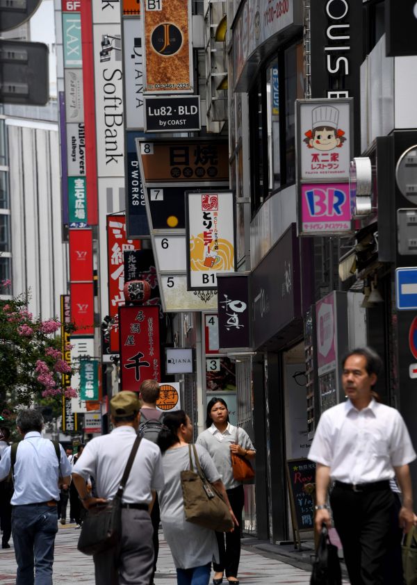 在日本东京，行人在涩谷商业区行走。 （新华社）