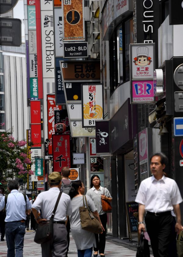 在日本东京,行人在涩谷商业区行走。 (新华社)