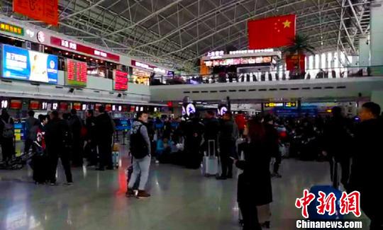 滞留旅客等候办理登机手续。 张权 摄 滞留旅客等候办理登机手续。 张权 摄