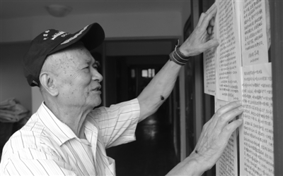 茅永贵老人正在张贴给居民的信.记者 刘波 摄