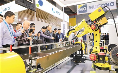 11月6日，在进博会装备展区，一组正在进行作业演示的焊接机器人吸引了参观者的目光。 　　新华社记者 方 喆摄
